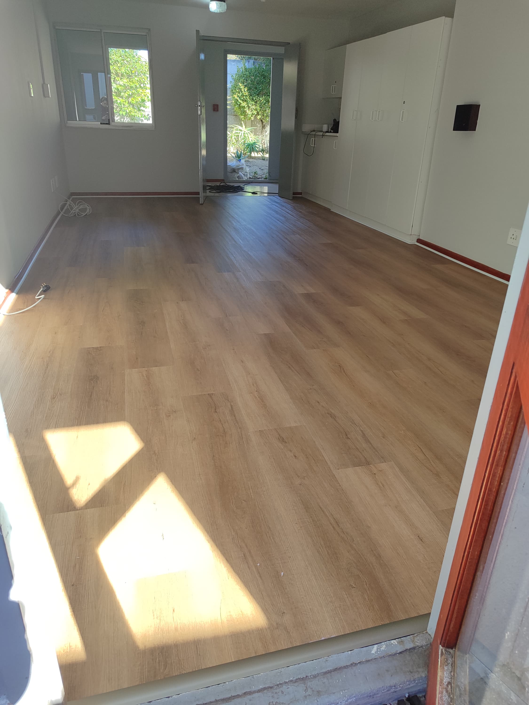 Warm-toned flooring in a room with sunlight on the floor